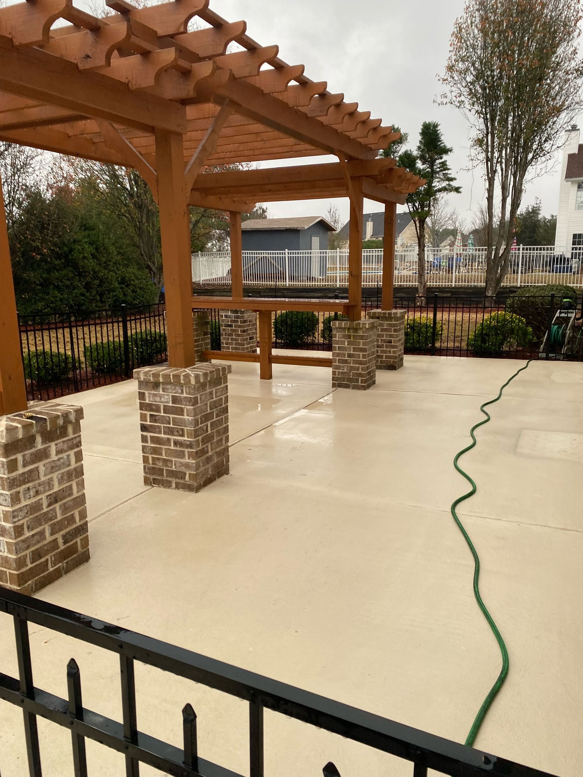 A worker using a high-pressure gasoline washer to deeply clean a driveway, providing professional pressure washing services.