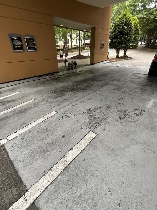 A car is parked in a parking lot next to a building.