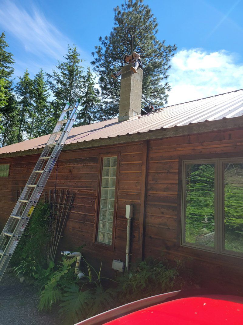 Man Cleaning The Chimney — Sandpoint, ID — Indoor Air Care