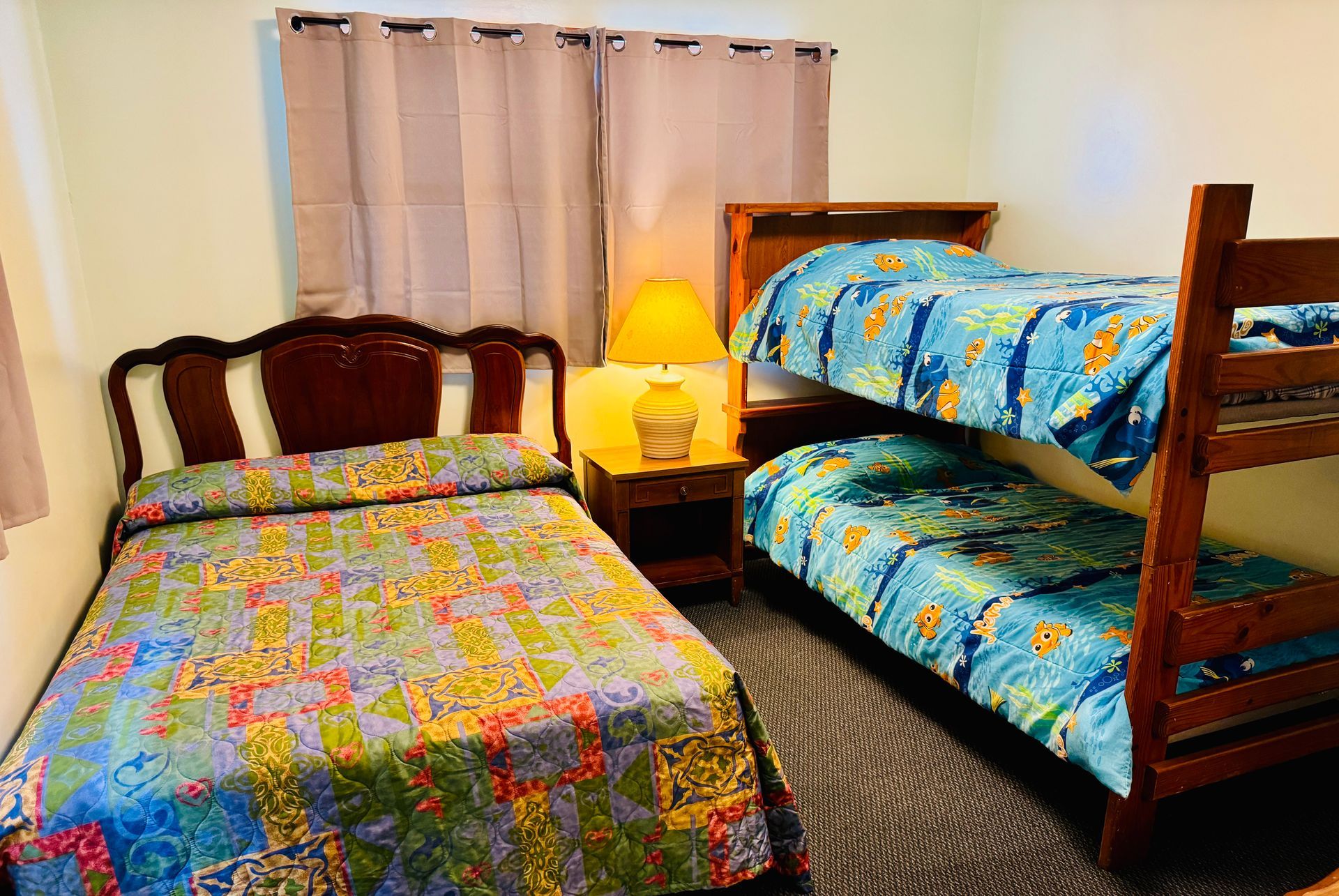 A bedroom with two beds and a bunk bed.