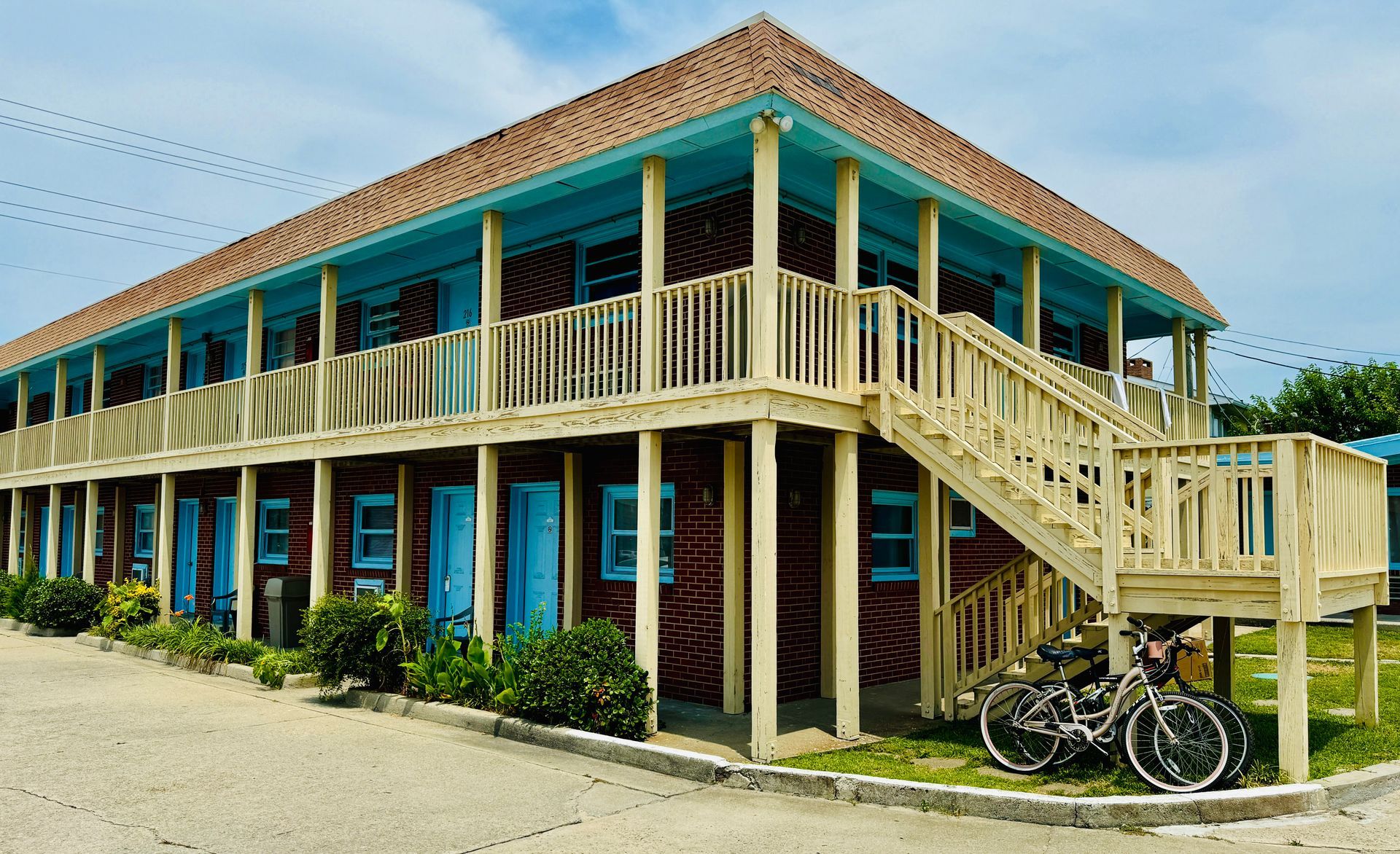 Two bicycles are parked in front of a large building with stairs