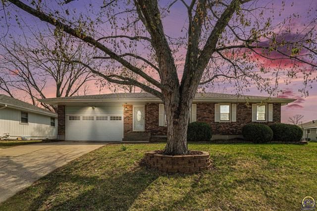 A dining room with a table and chairs and a wooden staircase.