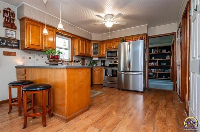 A living room with a couch , chairs , ottoman and a mirror