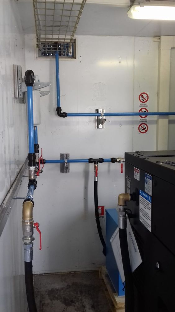 Una stanza con un sacco di tubi e una macchina al suo interno.