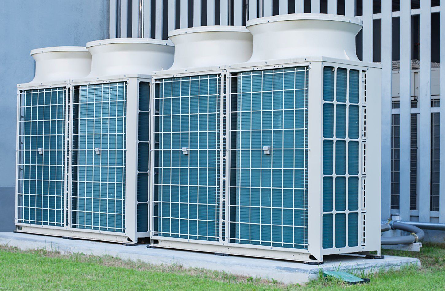 Una fila di condizionatori d'aria sono posizionati all'esterno di un edificio.