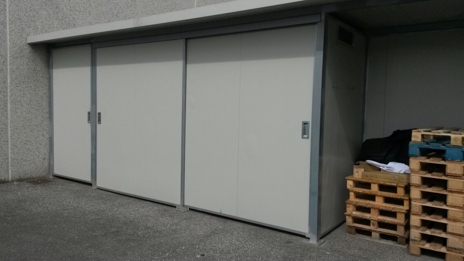 Un edificio con una fila di pallet di fronte