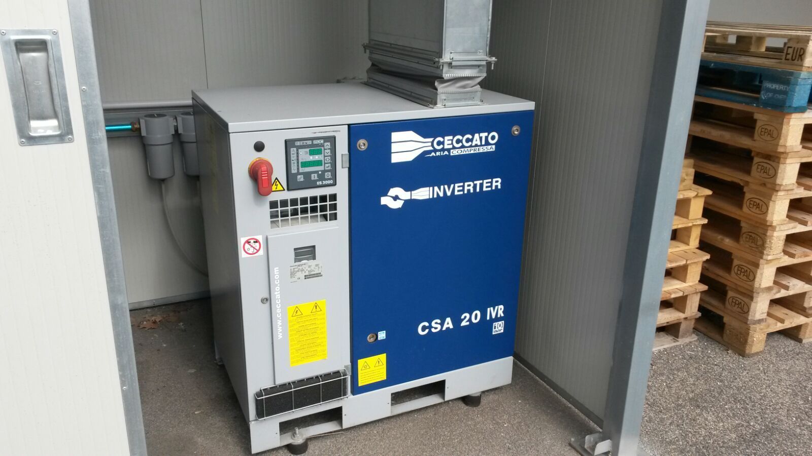 Una macchina è posizionata in una stanza accanto ai pallet.