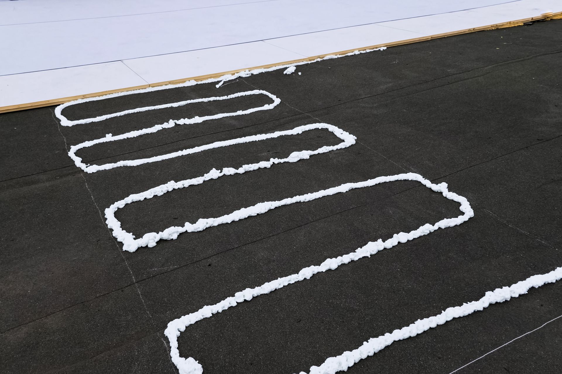 a row of white foam lines on a black surface