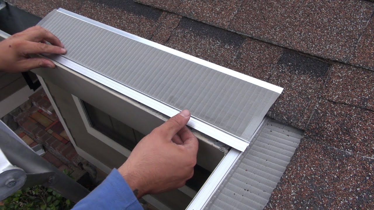 An installer fitting a gutter cover onto a residential gutter system, protecting it from debris and leaves.