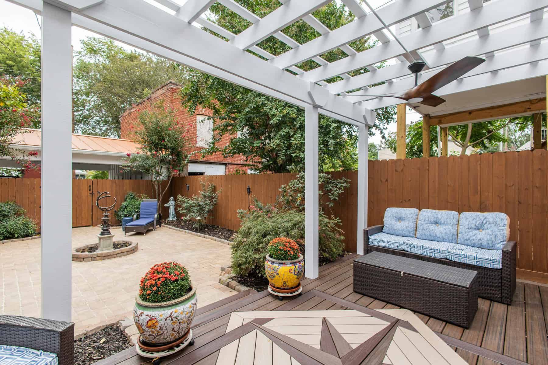 Outdoor patio with a pergola, furniture, and a fountain.