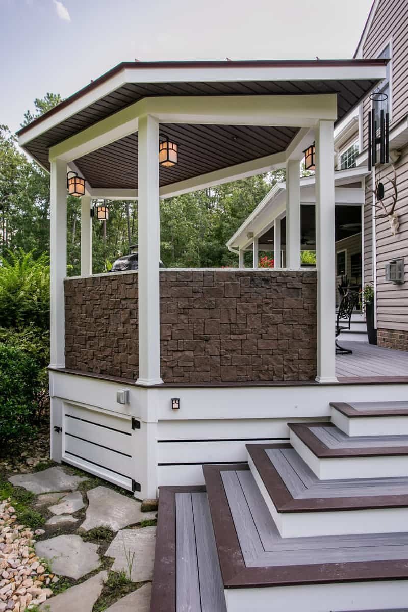 Multi-level wooden deck with a gazebo-like structure. Steps lead up to the raised deck area.
