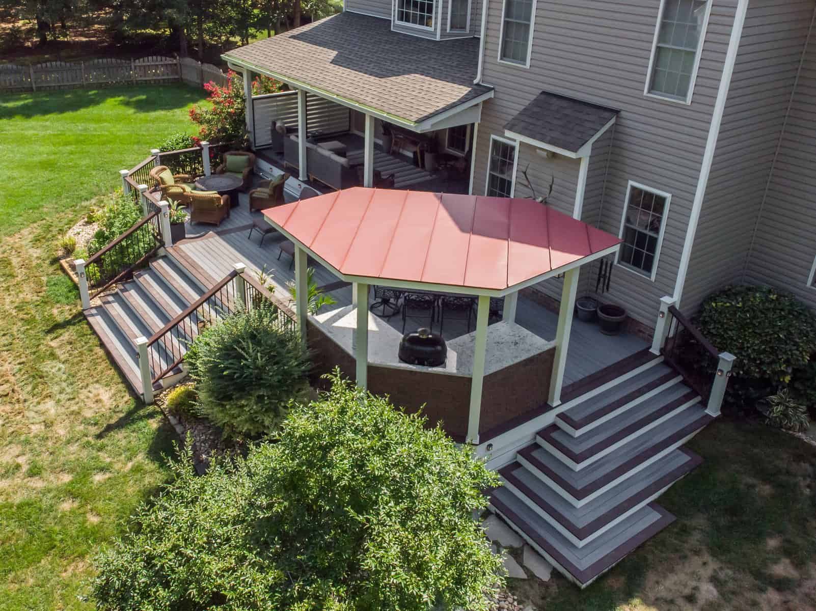 Elevated backyard deck with gazebo, steps, and house. Green lawn surrounds the space.