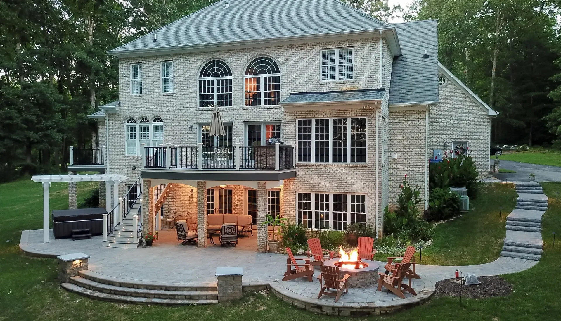 Large stone house with an outdoor patio, fire pit, and upper deck.