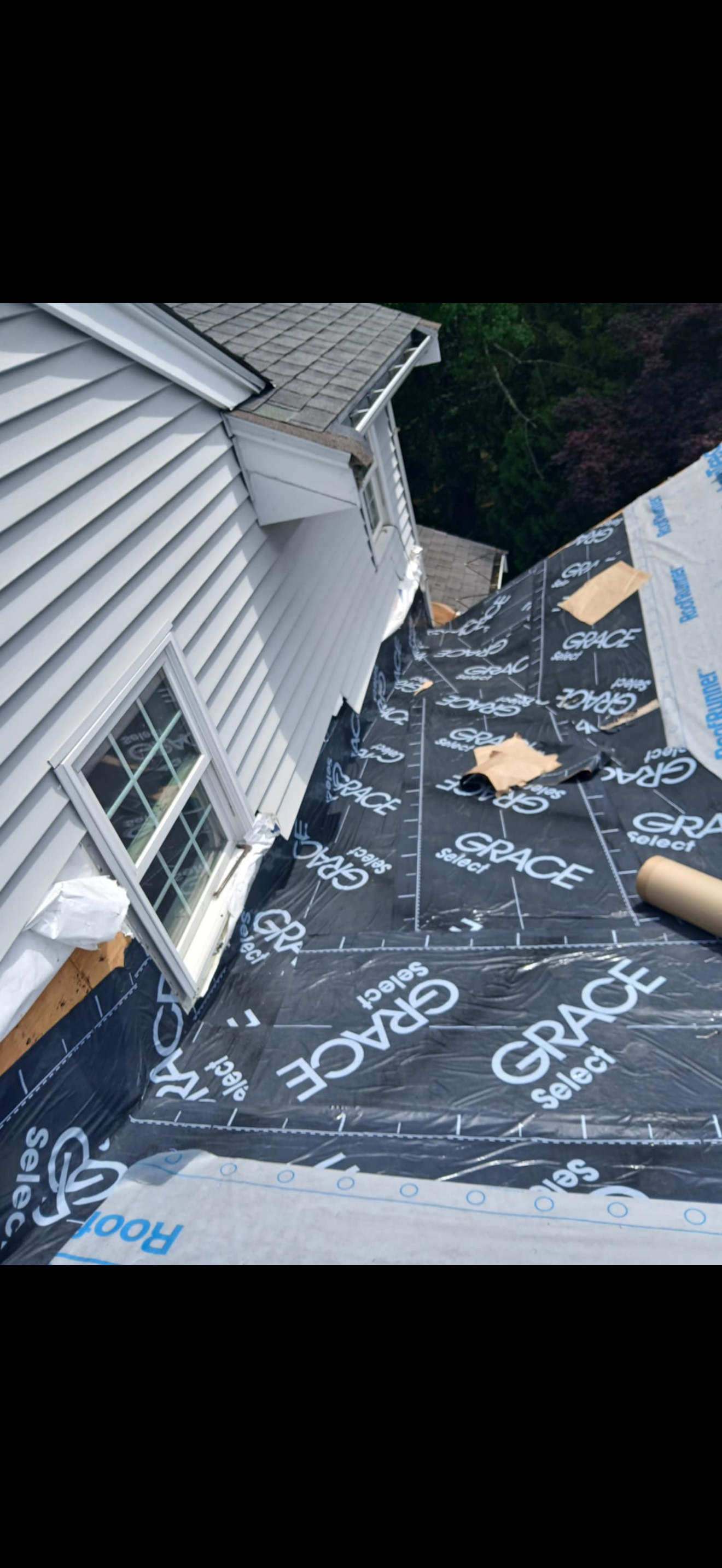 A house with a new roof installation. Black underlayment is in place.