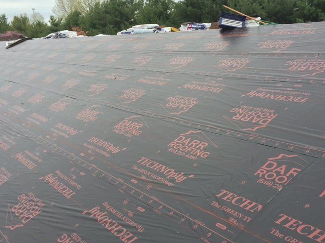 A roof with a lot of black sheets on it