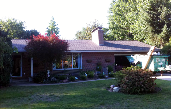 A brick house with a green box in front of it