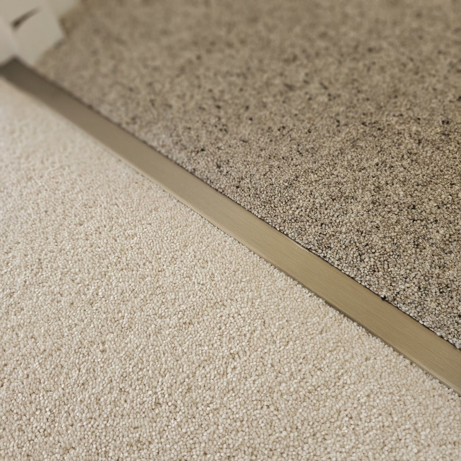Contrasting carpets separated by stainless steel door bar in Dartmouth