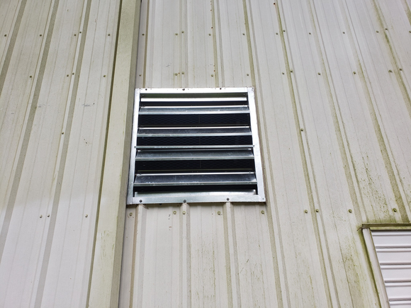 Ventilation grate set in a metal wall.