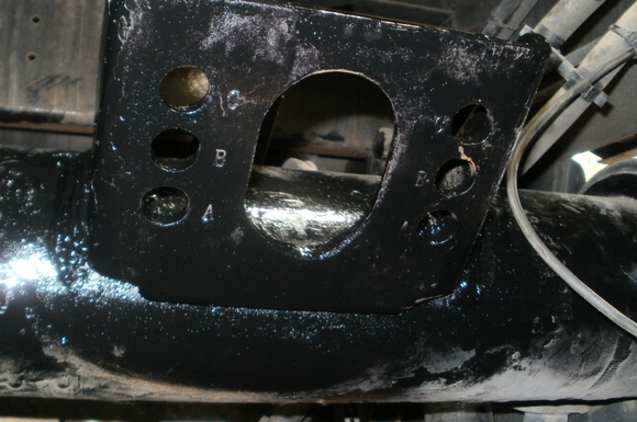 Blue industrial ductwork bends at a right angle, bolted to a wall.