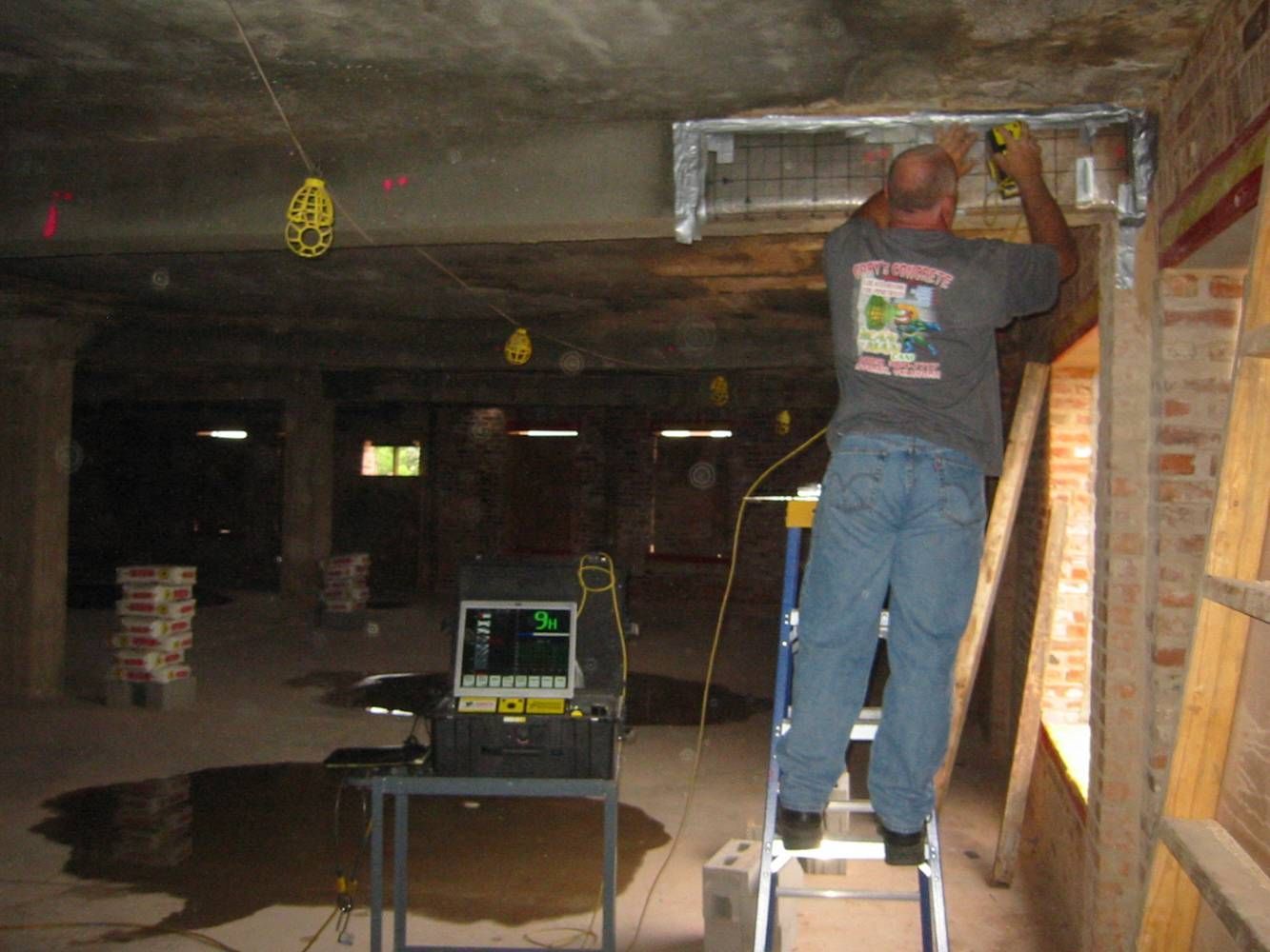 A man is standing next to a robot on the ground.
