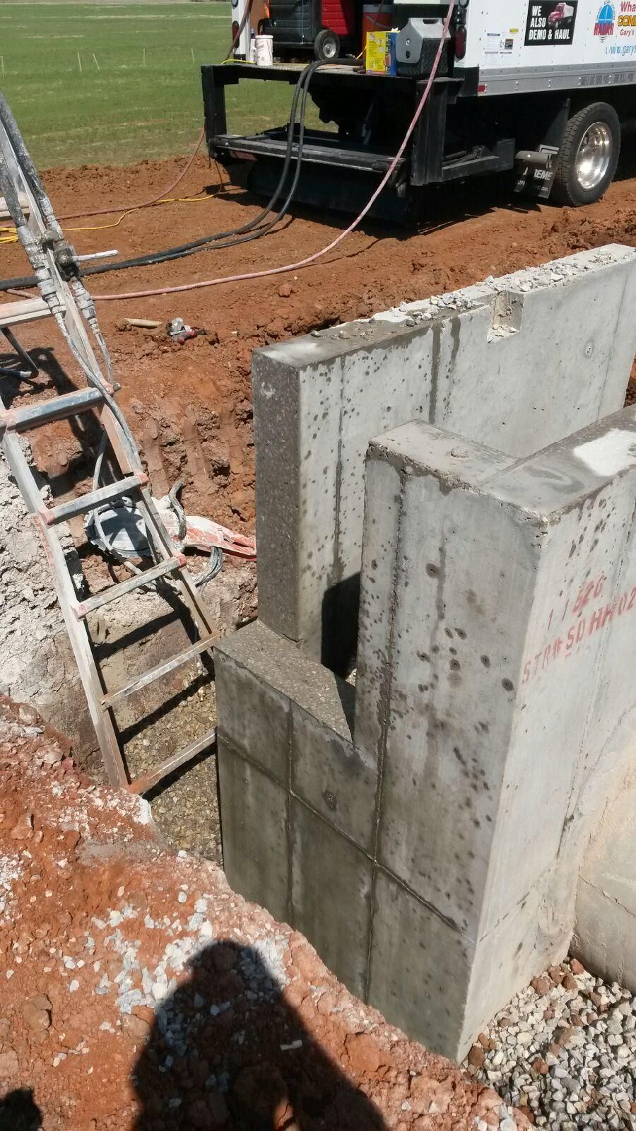 A man is cutting a hole in a wall with a chainsaw.