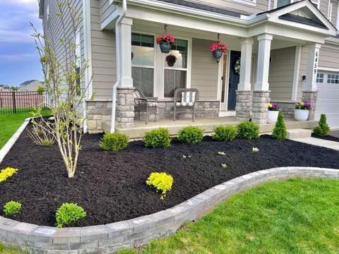 A house with a large porch and a lush green lawn.