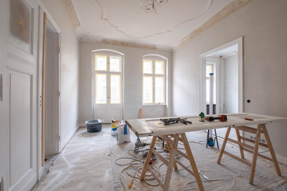 A room under construction with a table and tools in it.