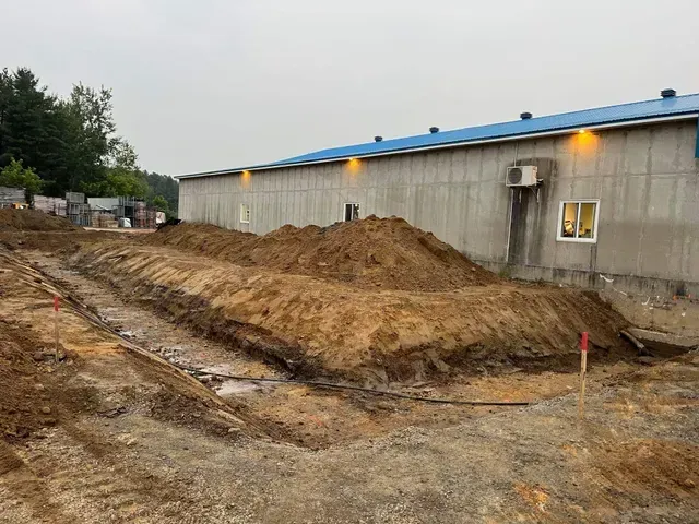 Un gros tas de terre se trouve devant un bâtiment.
