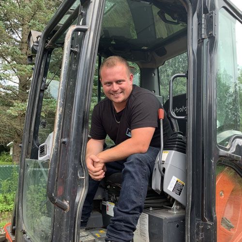 Un homme est assis sur le siège conducteur d'un véhicule de construction.