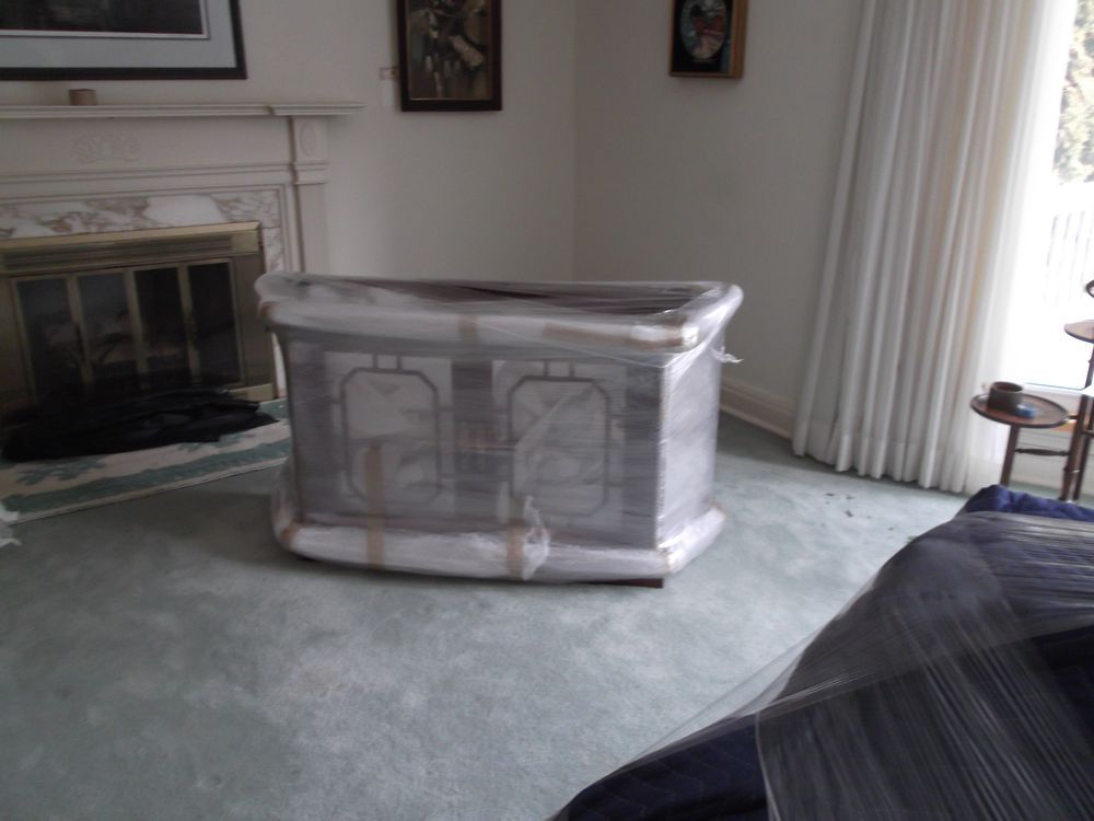 Wrapped cabinet in a room with fireplace and curtains.