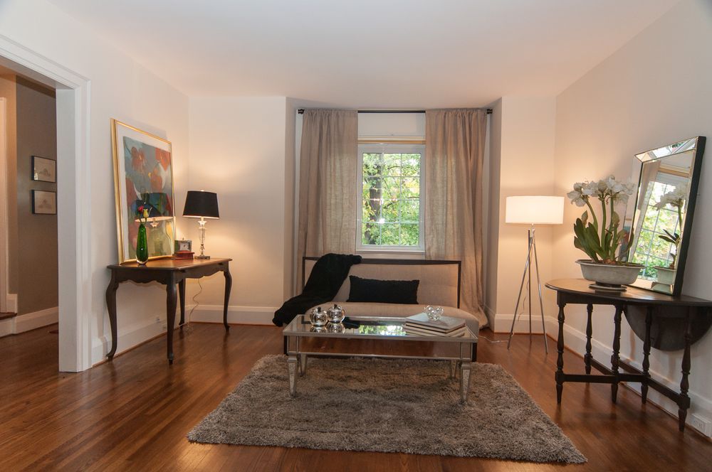 Living room with dark wood floors, light walls, and elegant furniture.