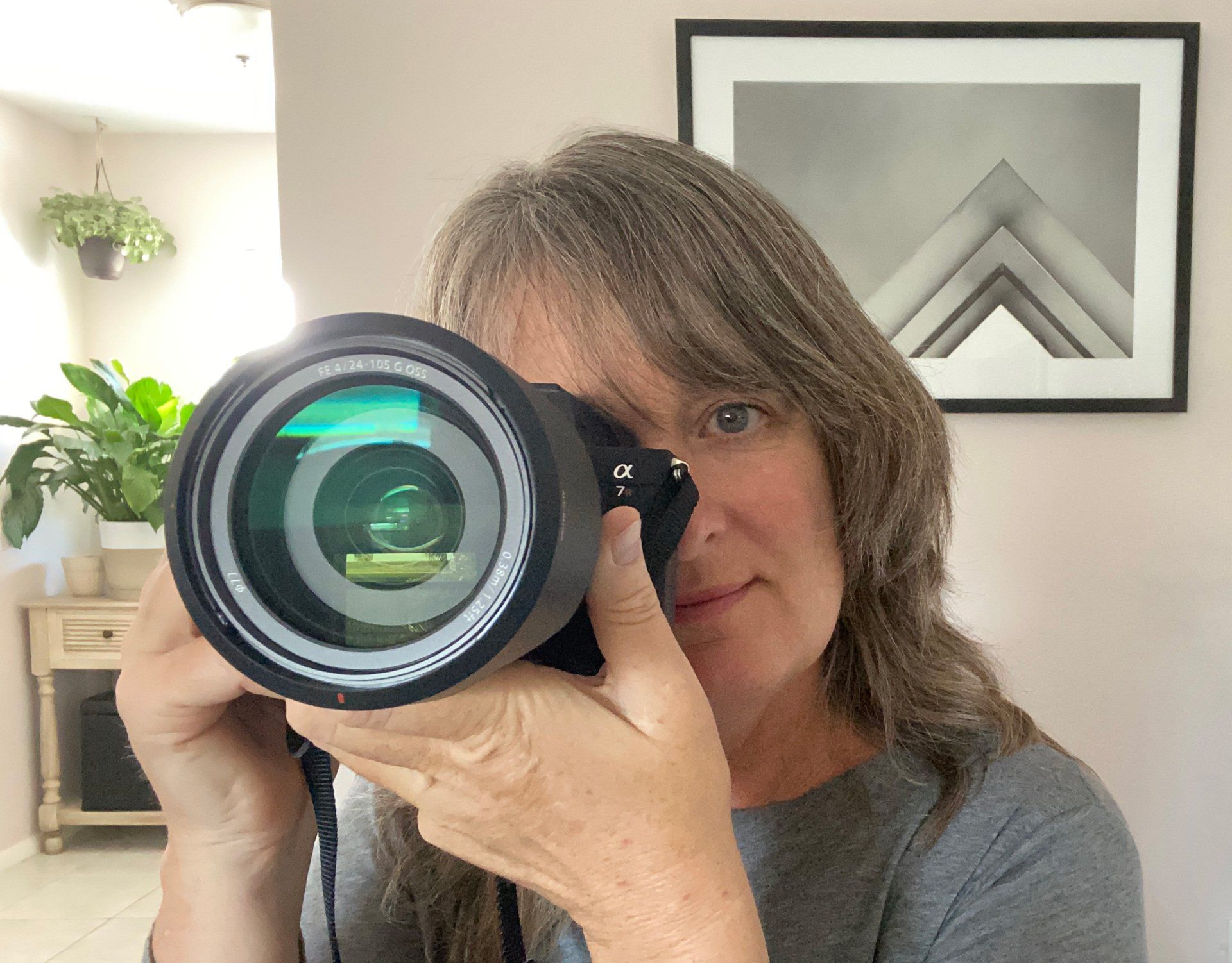 female photographer faces her lens directly at the viewer in a self-portrait style shot