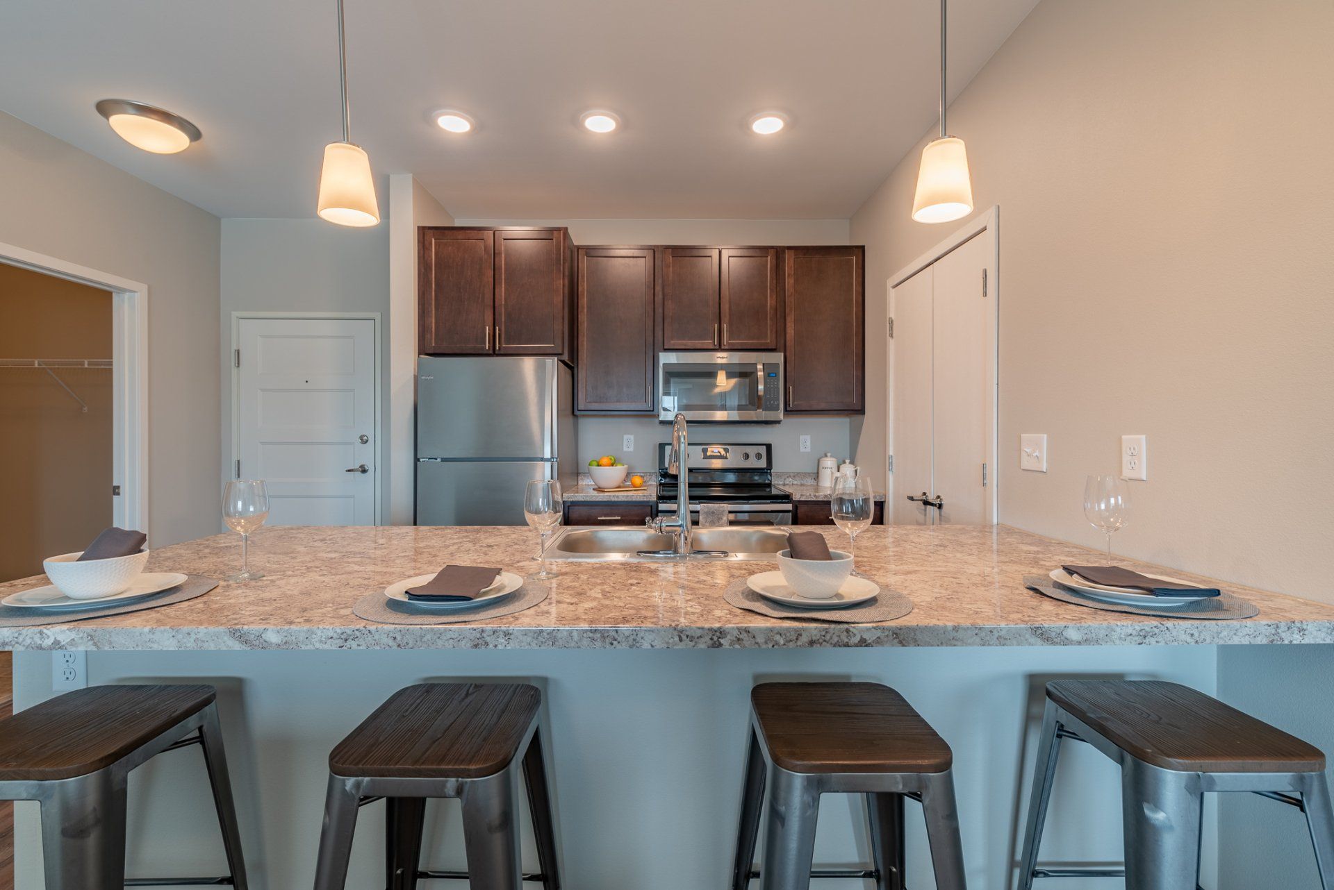 Alternate view of kitchen island with granite countertops and stainless steel sink