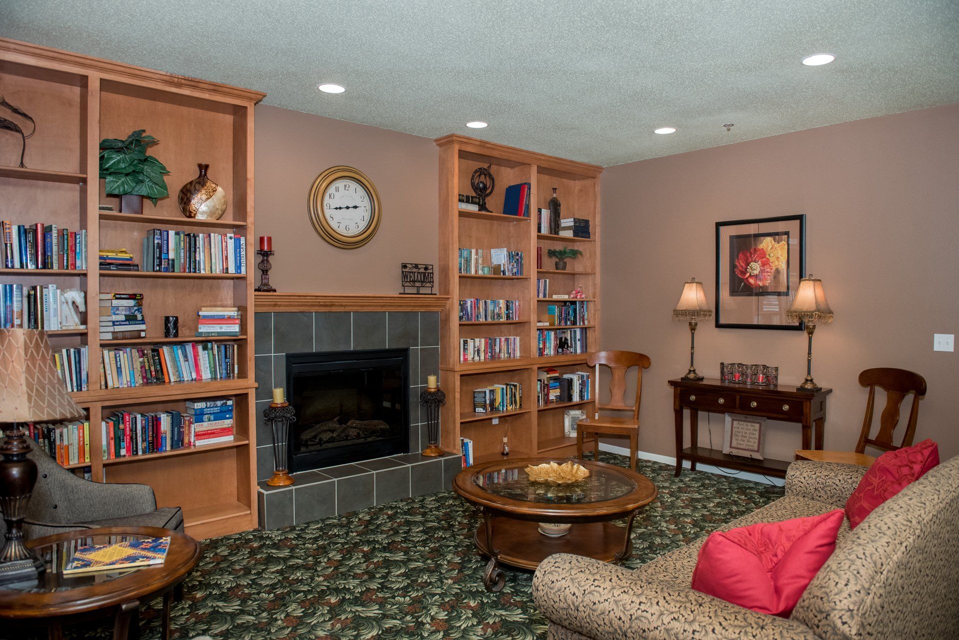Living room with large fireplace, bookshelves, and round dining table