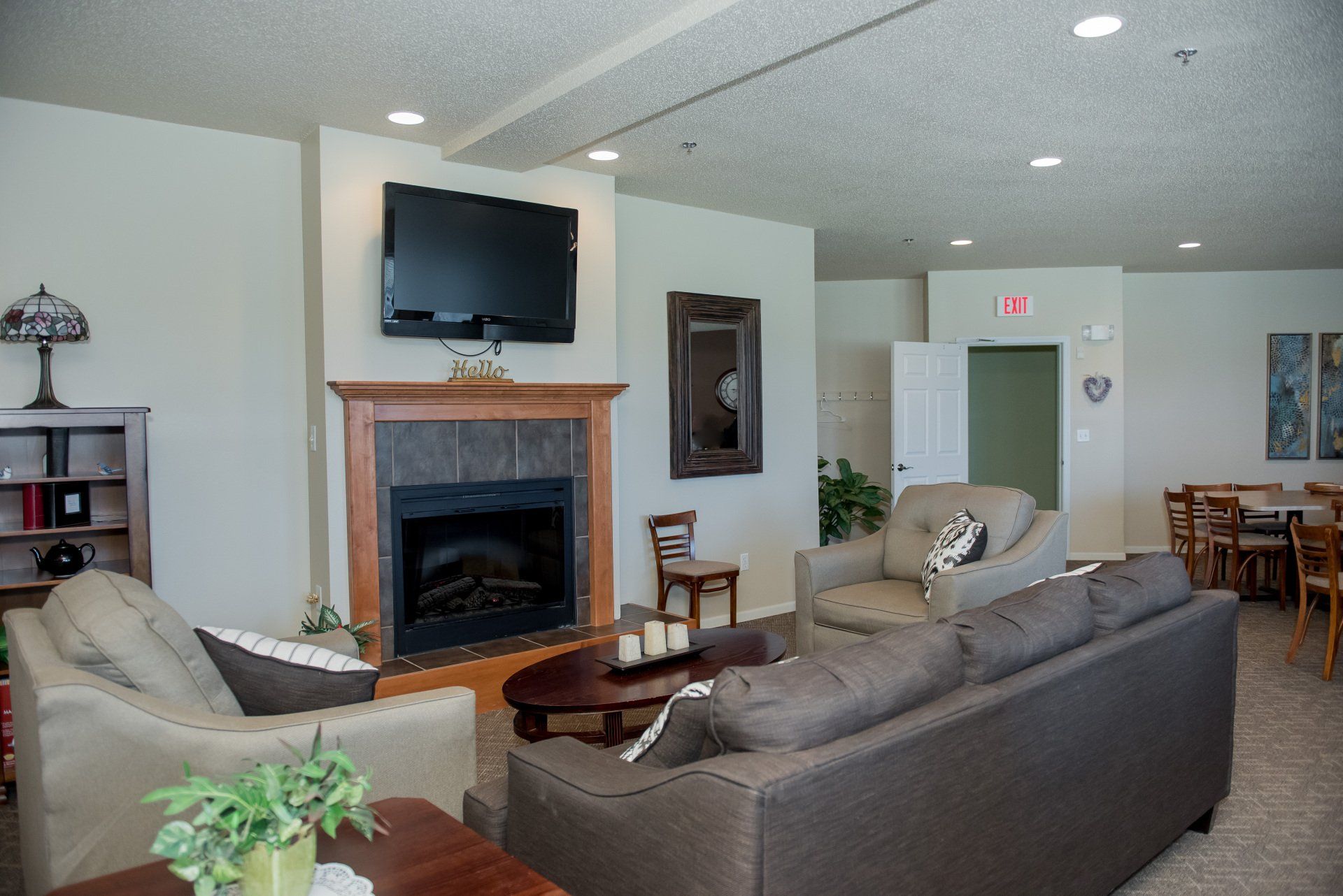 Alternate living room with fireplace, and large television over fireplace