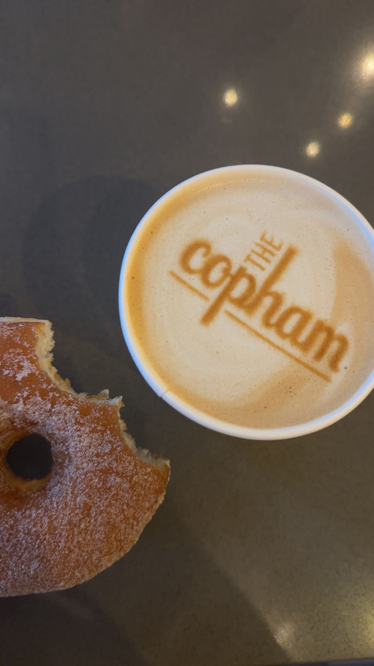 The Copham logo laser etched onto a latte
