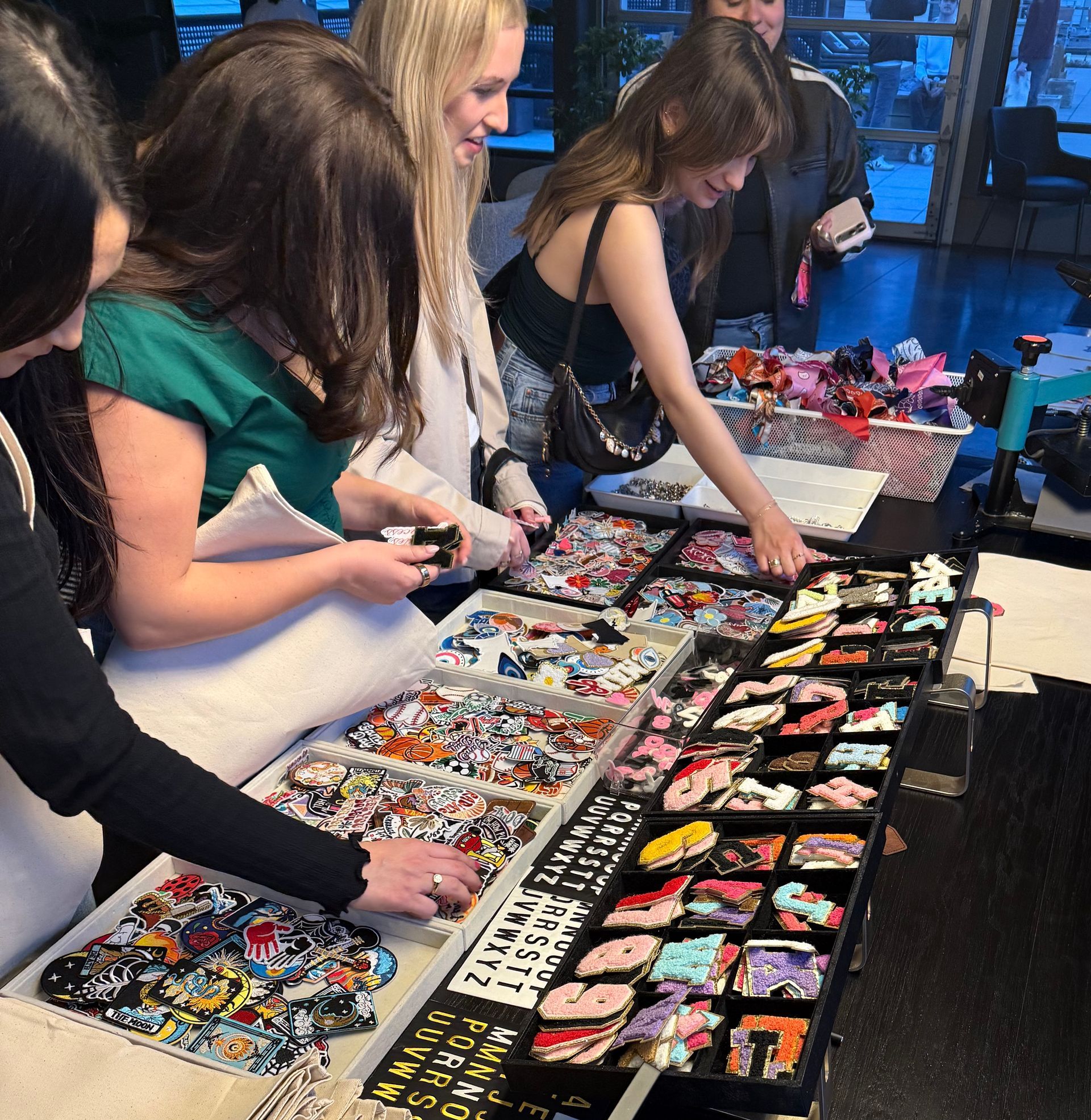 Residents sort through charms and patches at the bag making station during The Copham welcome week