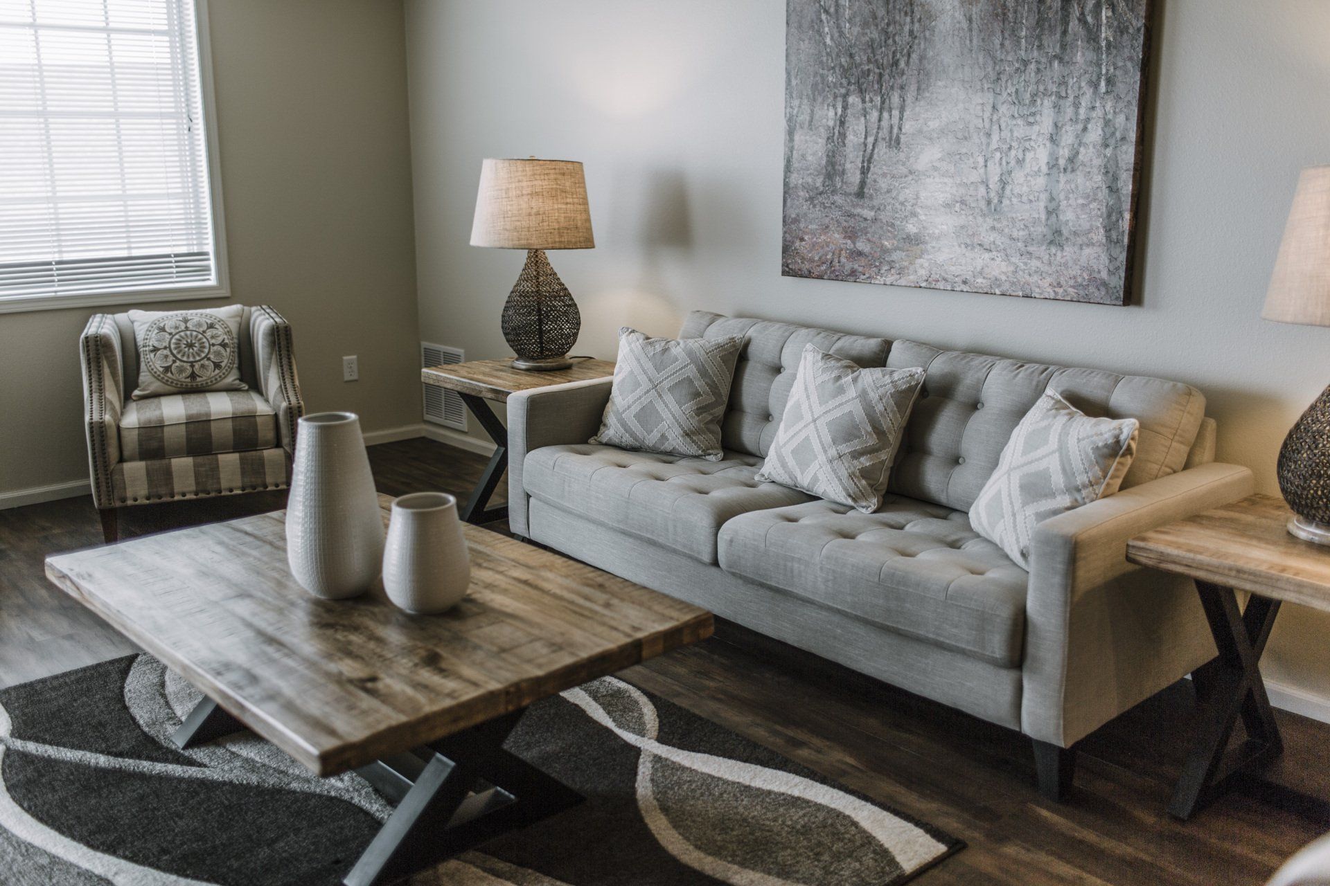 Living room with hardwood floors, grey couch, and wooden coffee table