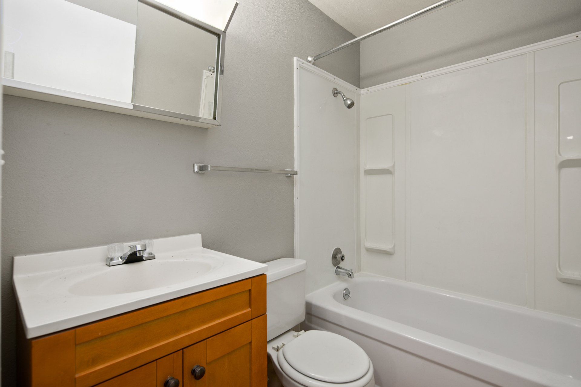 Bathroom interior with white fixture, toilet, and tub shower combo