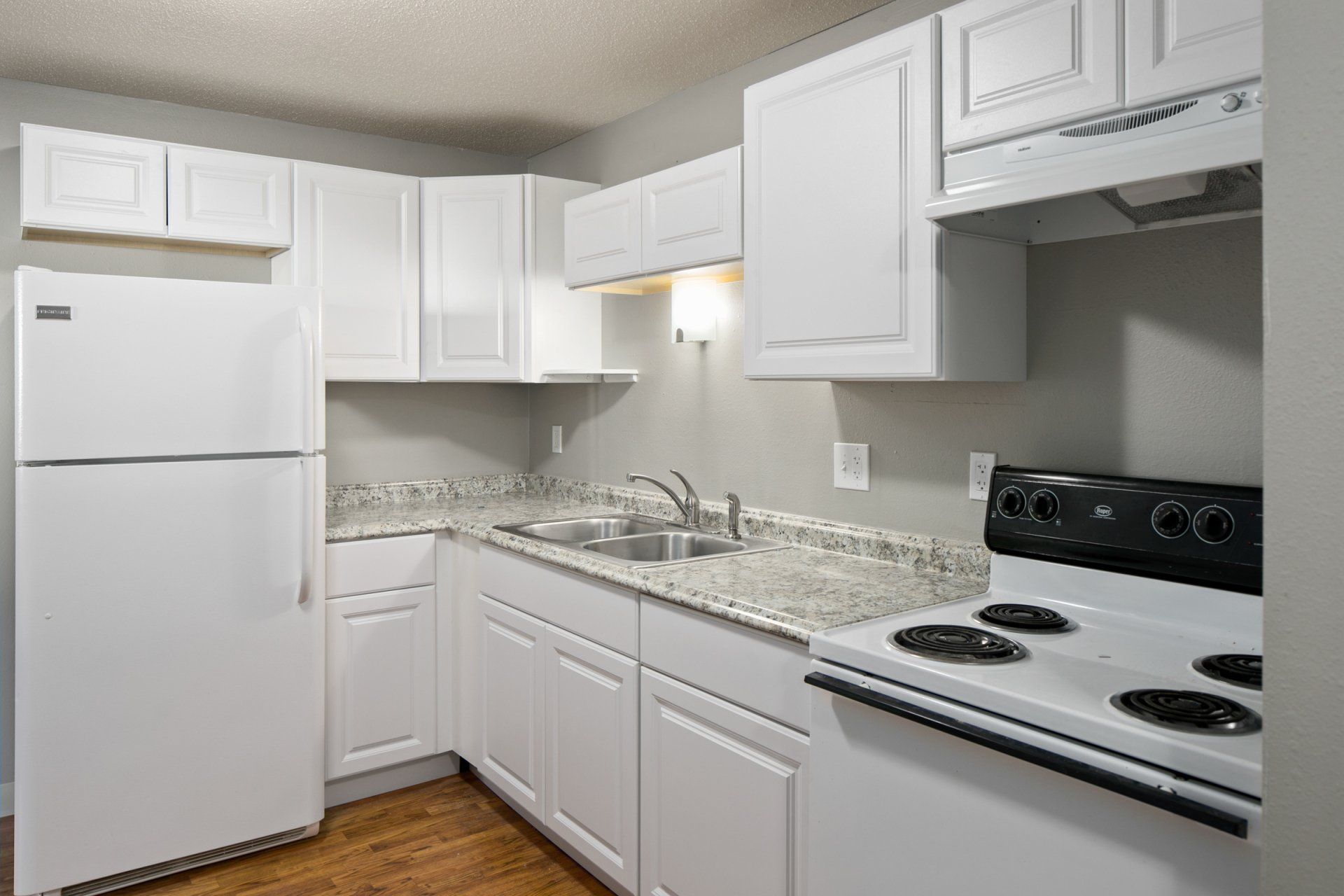 Interior of kitchen with white cabinetry and appliances