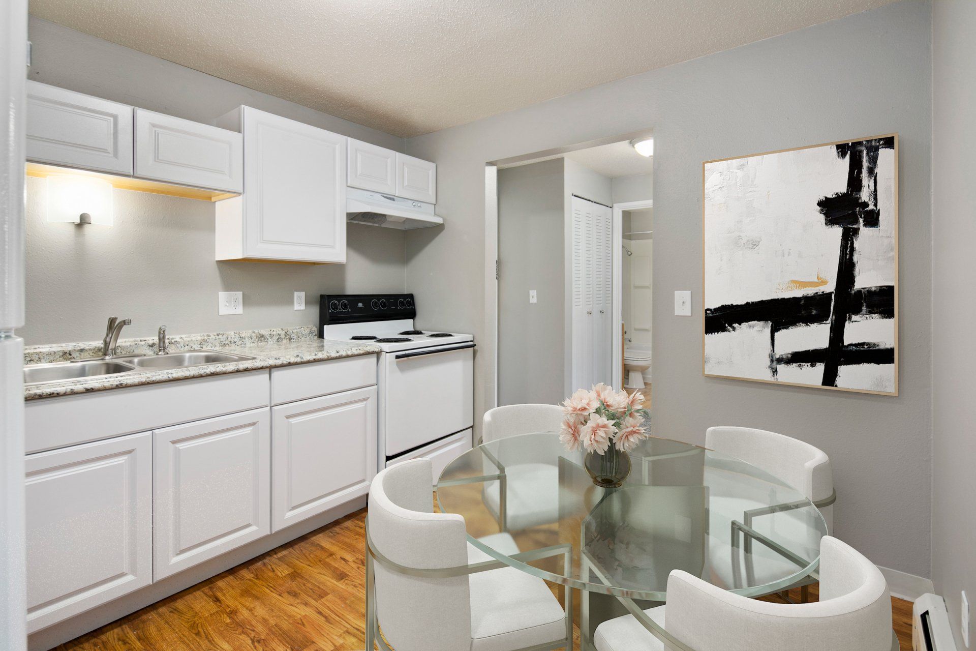 Glass dining table in kitchen with hardwood floors