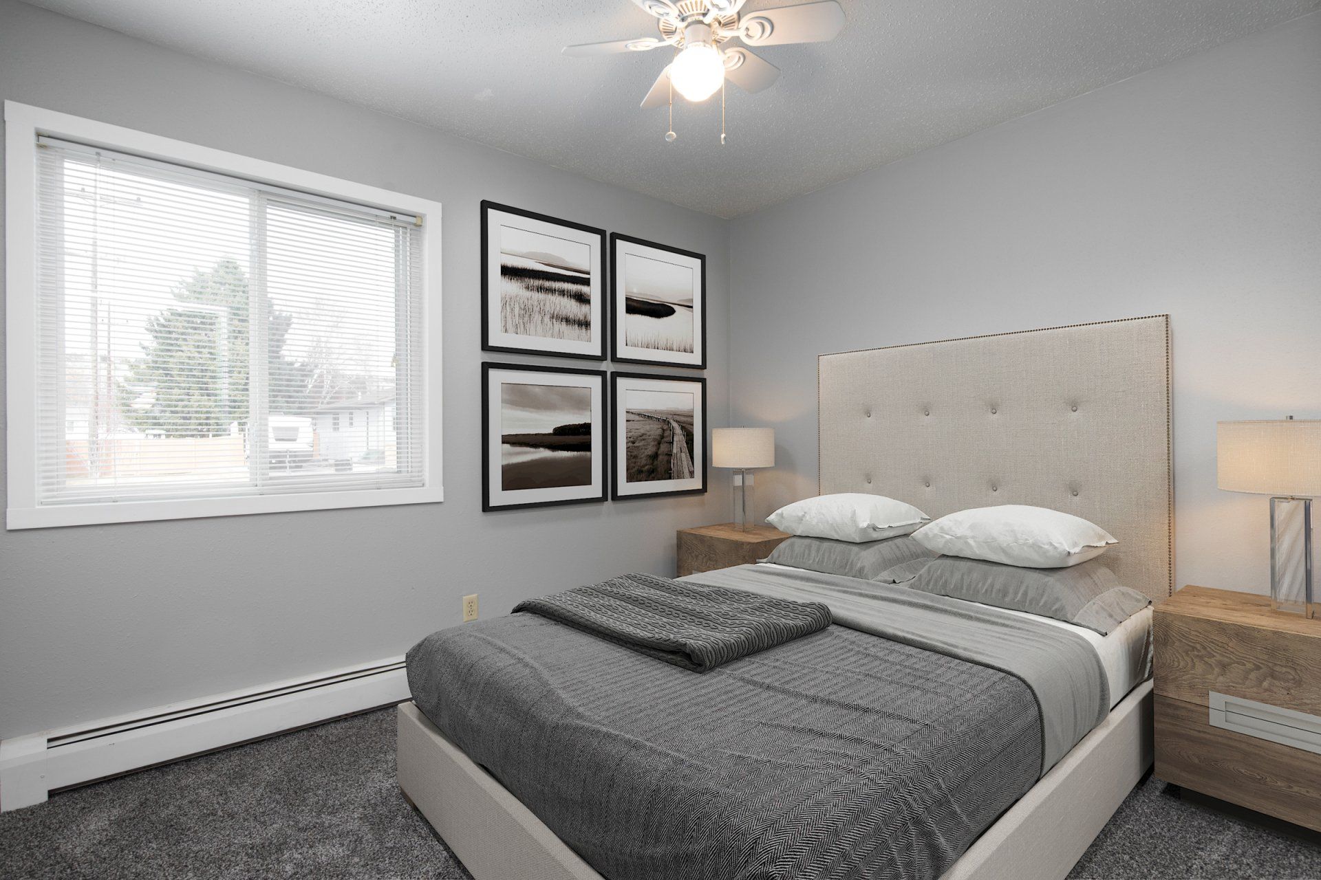 Alternate view of large bedroom with ceiling fan, large window, and white walls