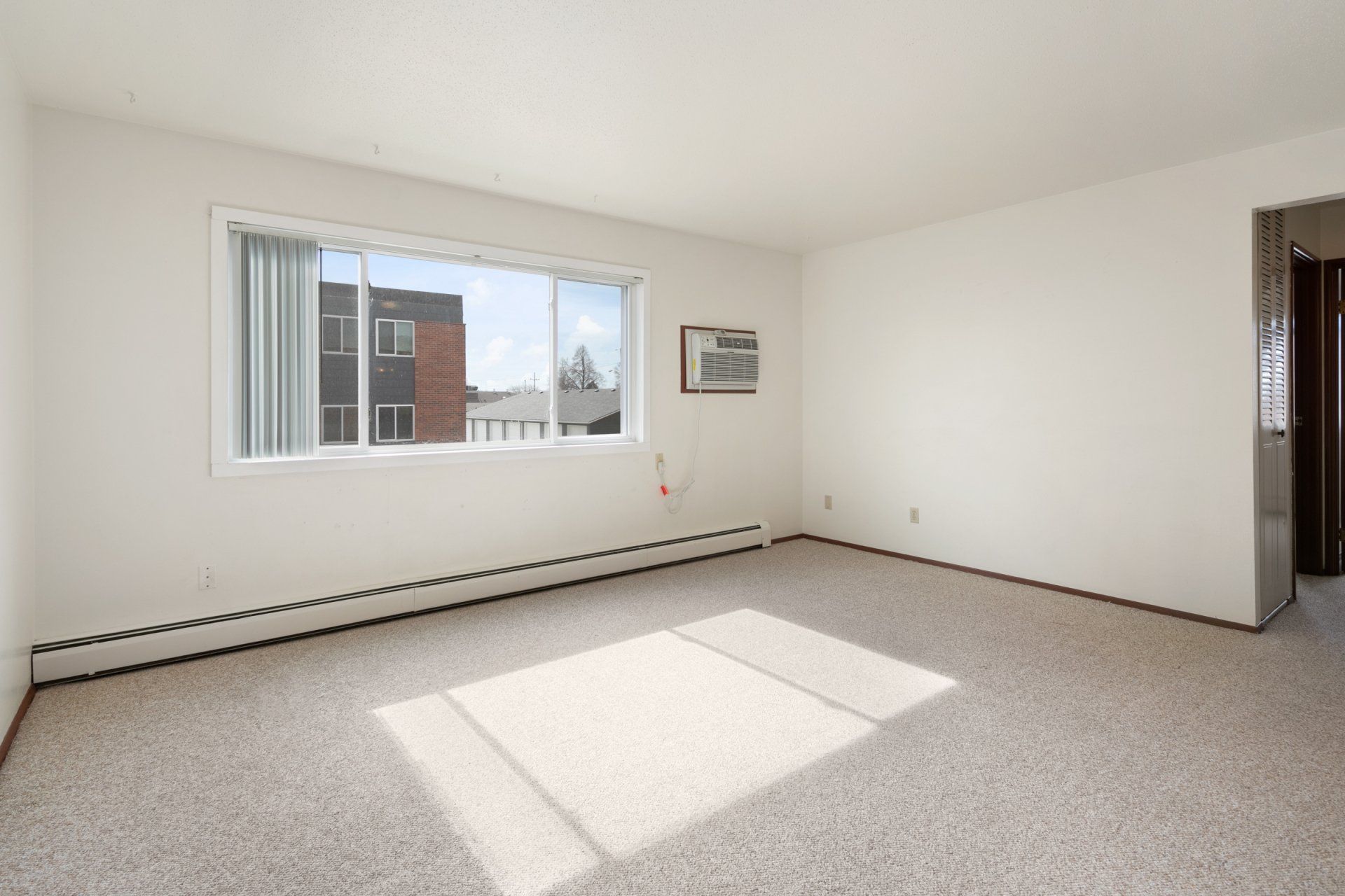 Bedroom with white walls, carpet, and a window