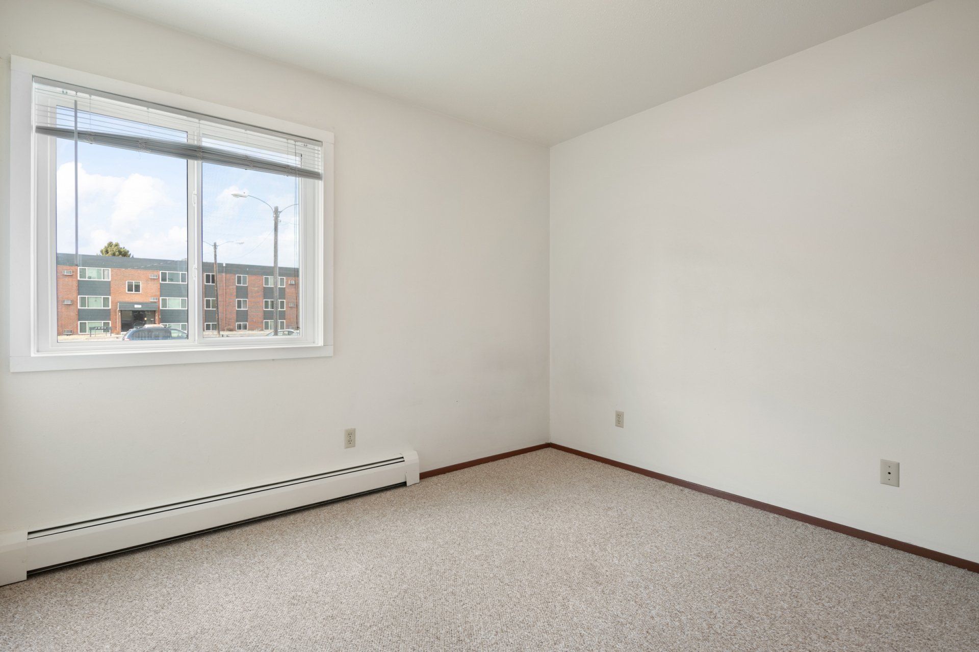 Empty bedroom with window and carpeted floors