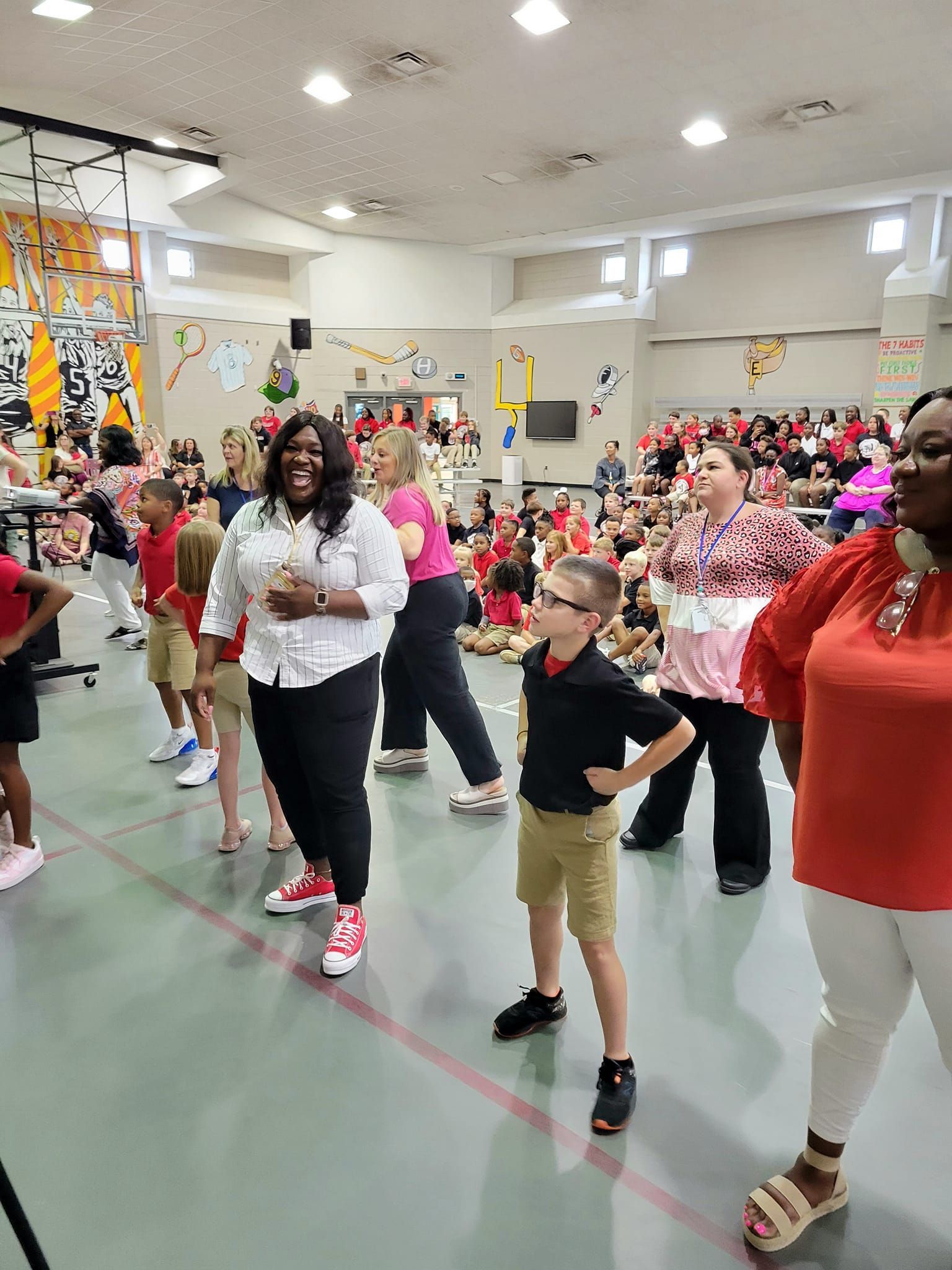 a group of people are standing in a gym .