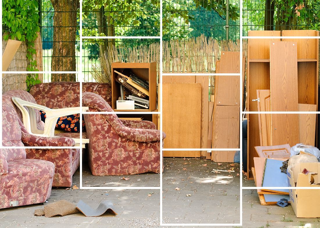 A bunch of furniture is sitting on the ground in a yard.