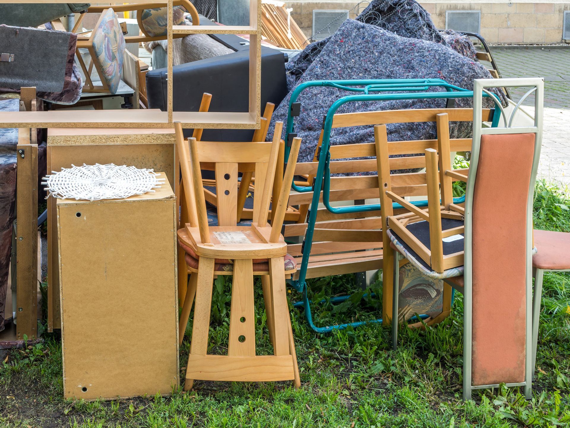 A pile of furniture is sitting on top of a lush green field.