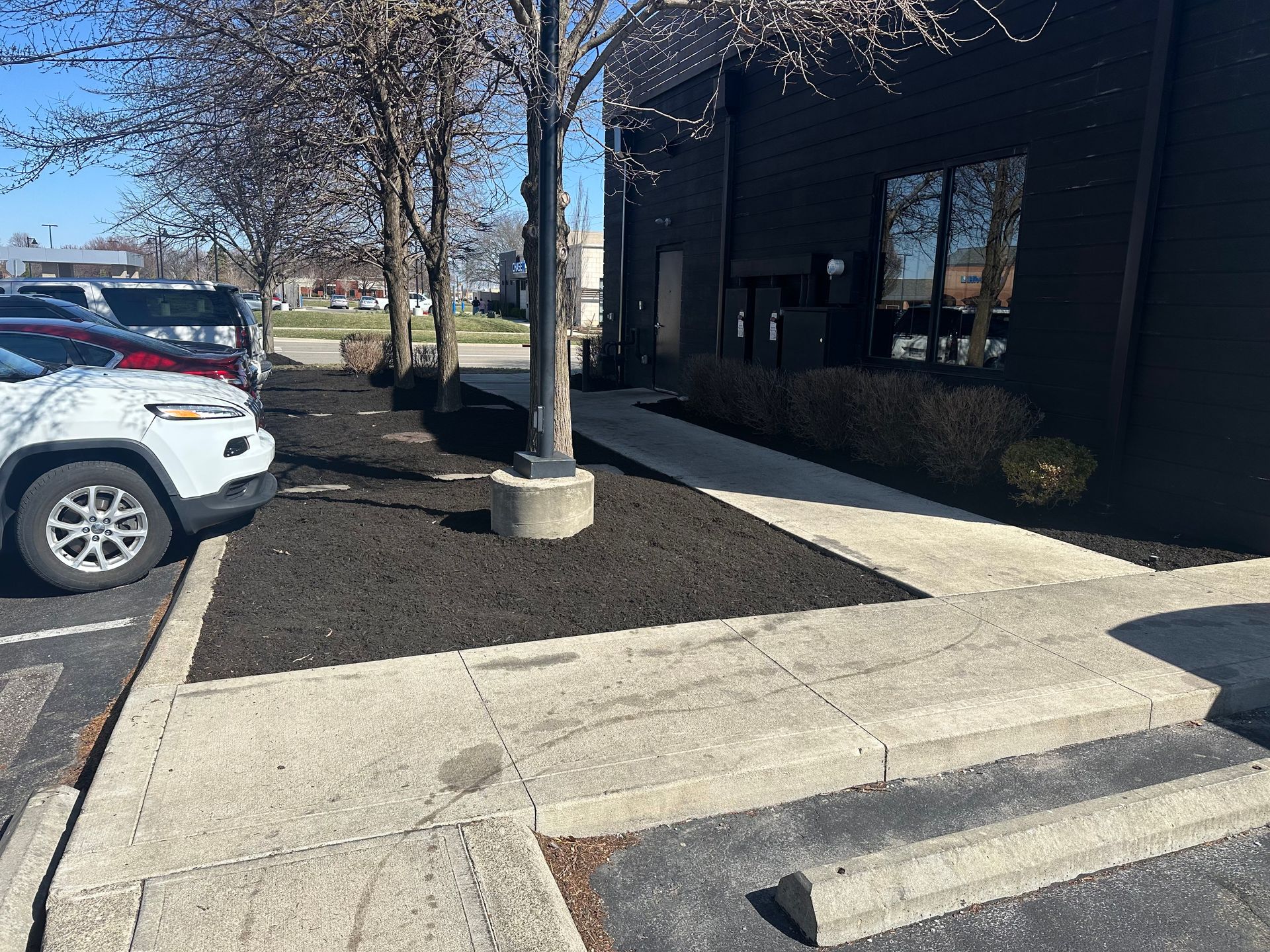 A parking lot with cars parked in front of a building.