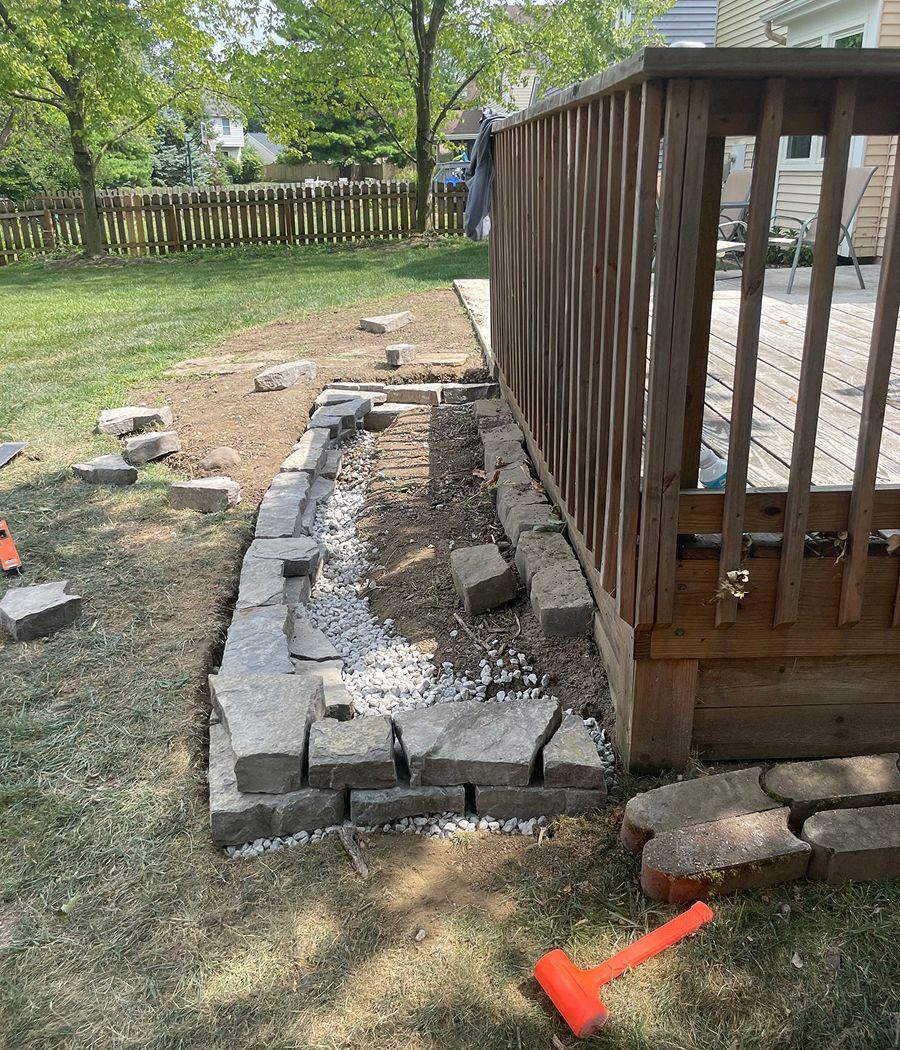 A wooden deck is being built in a backyard.