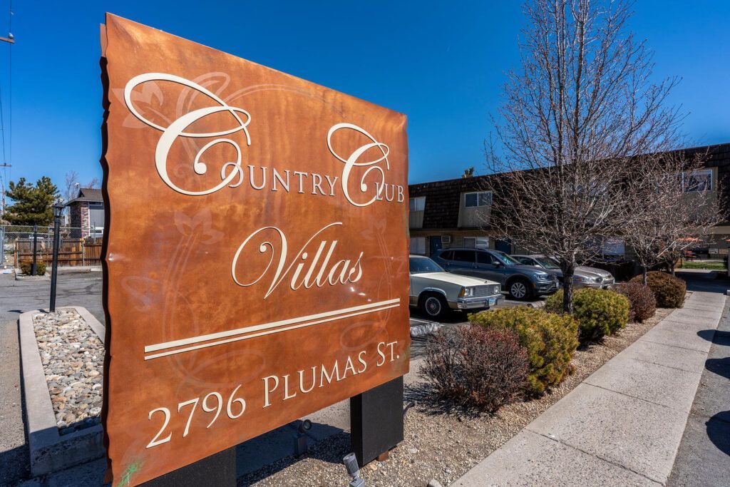 A sign that says country village is on the sidewalk in front of a building.